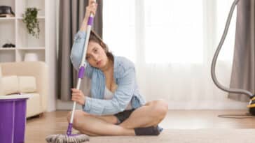 tired woman after cleaning apartment floor with mop